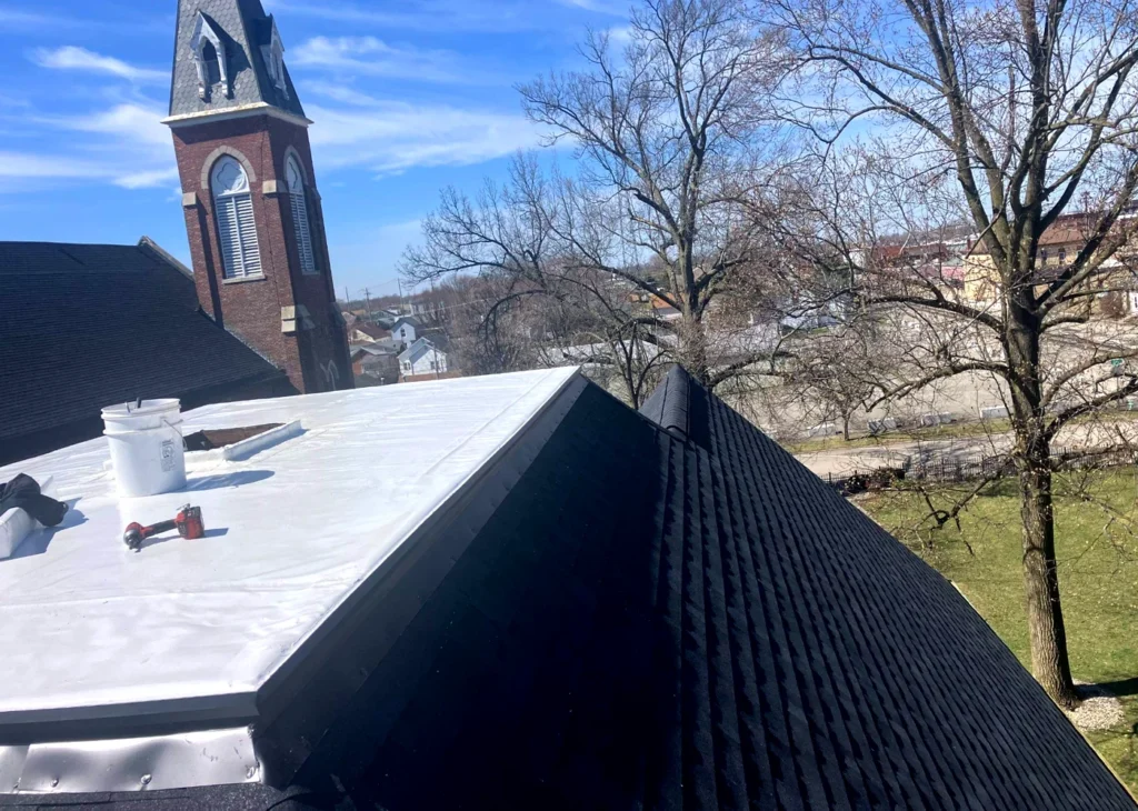 Church roofing project with architectural shingles and flat membrane system installed on institutional building